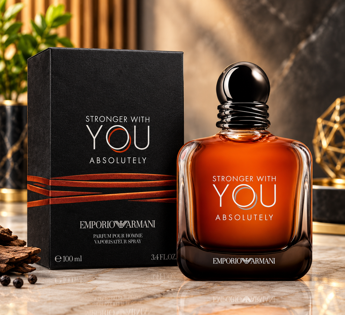 Emporio Armani Stronger With You Absolutely Eau de Parfum bottle and its black packaging box, displayed on a marble surface with a warm, elegant background.