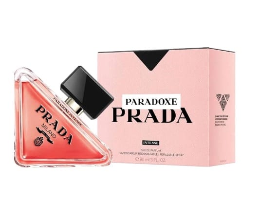 Prada Paradoxe Prada Intense Eau de Parfum bottle with a triangular shape filled with pink liquid, shown next to its light pink packaging box on a white background.
