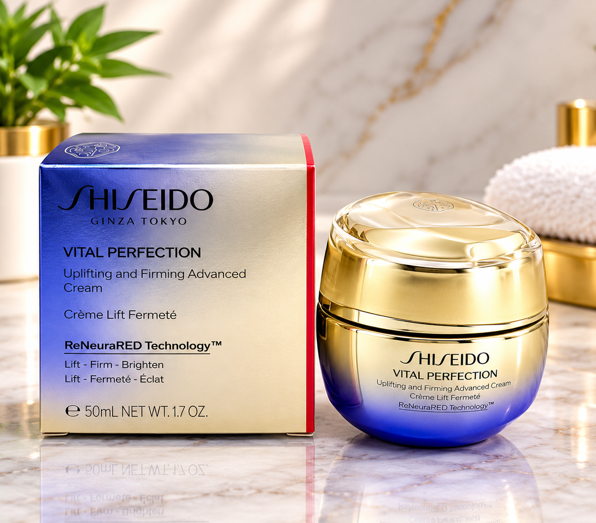 Shiseido Vital Perfection Uplifting and Firming Advanced Cream shown with its blue and gold outer box and the open cream jar on a marble surface.